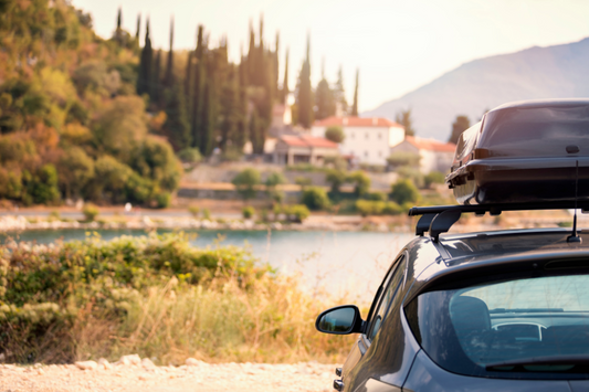 Carro com objeto no tejadilho e uma paisagem à sua frente para retratar o tema sobre cuidados com o carro antes de viajar